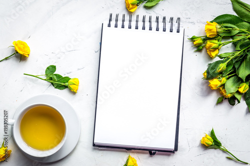 lifestyle concept with tea and roses on home desk top view mock-