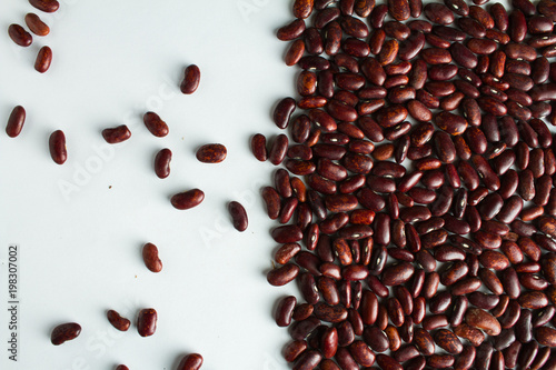 Beans are evenly scattered on a white table.