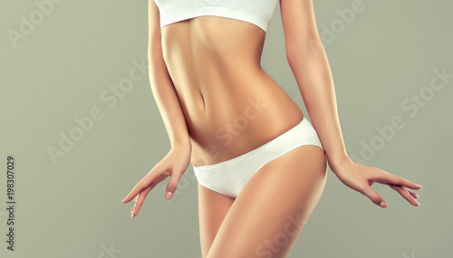  Perfect slim toned young body of the girl . An example of sports , fitness or plastic surgery and aesthetic cosmetology.
