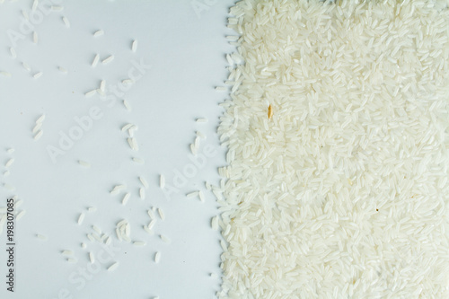 The rice is evenly scattered on a white table.