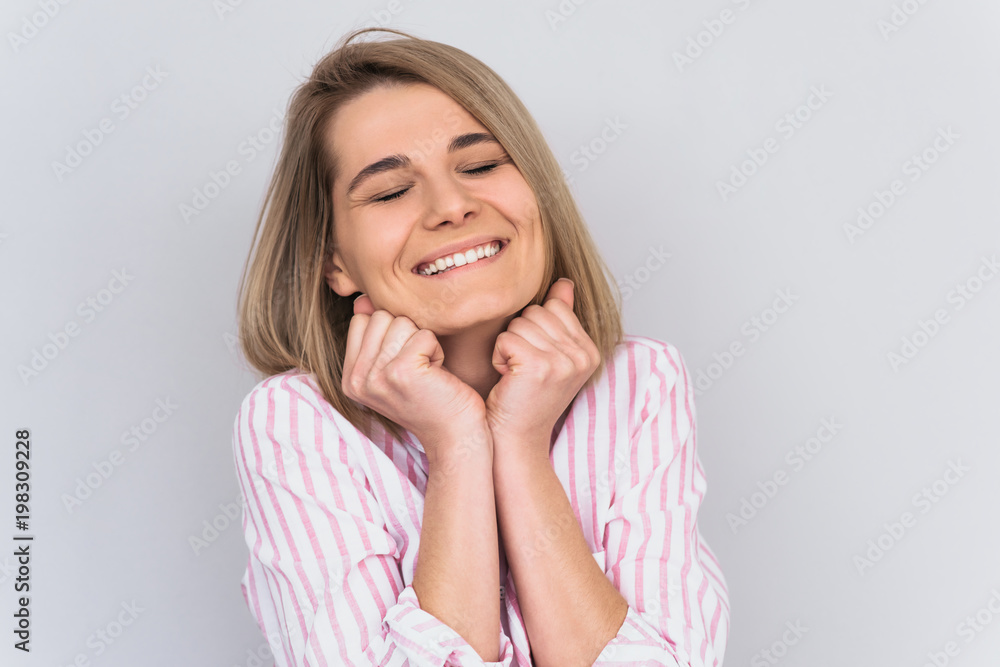 Horizontal portrait of dreamy and beautiful young blonde woman wearing casual pink shirt, smiling, narrowing her eyes, looking happy. Cute positive brunette female with healthy white teeth smile. Horizontal portrait of dreamy and beautiful young blonde woman wearing casual pink shirt, smiling, narrowing her eyes, looking happy. Cute positive brunette female with healthy white teeth smile.