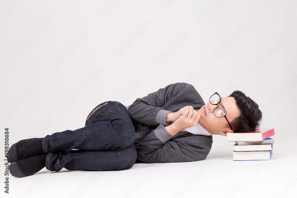 Young Asia graduate student sleep with his book. Studio shot on white background. Concept for Education Young Asia graduate student sleep with his book. Studio shot on white background. Concept for Education