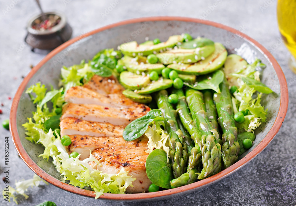 Chicken fillet cooked on a grill with a garnish of asparagus and grilled avokado. Dietary menu. Healthy food Chicken fillet cooked on a grill with a garnish of asparagus and grilled avokado. Dietary menu. Healthy food