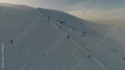 Aerial shooting, ski slopes and people that ski, snow-covered mountain photo