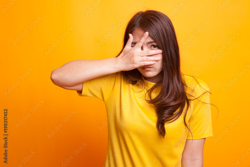 Beautiful young Asian woman peeking through fingers. Beautiful young Asian woman peeking through fingers.