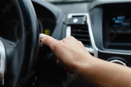 Hand holding switch light of car. © korchemkin