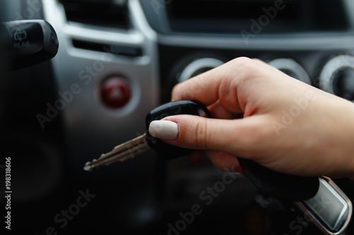 Car keys in the hand of a girl in the car interior. Woman holding car keys. Close up Hand