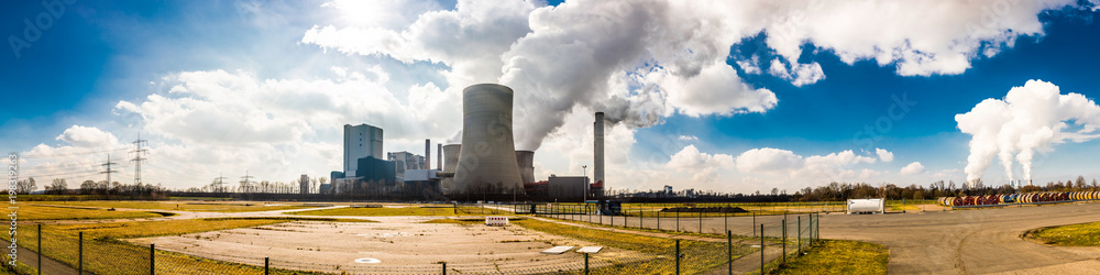 Panorama of an area with a big power plant with smoking cooling towers