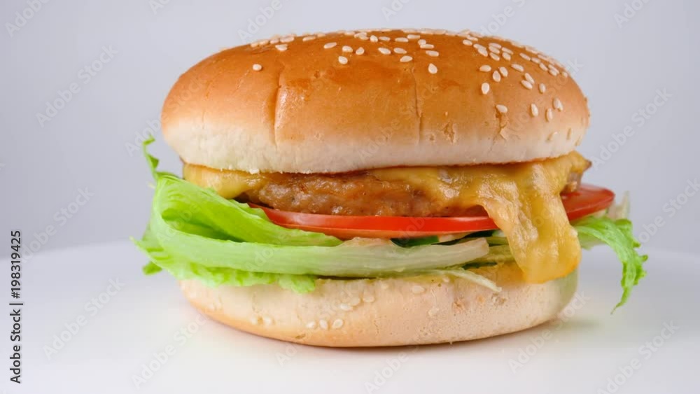 Cheeseburger with chicken and fresh vegetables, lettuce salad, tomatoes, cucumber and cheese, served in restaurant, loop Cheeseburger with chicken and fresh vegetables, lettuce salad, tomatoes, cucumber and cheese, served in restaurant, loop