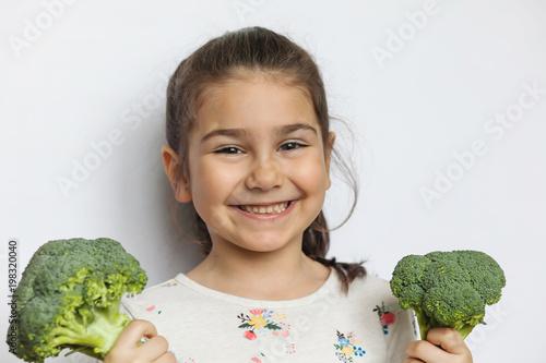 Happy smiling child girl with vegetables. Healthy food.
