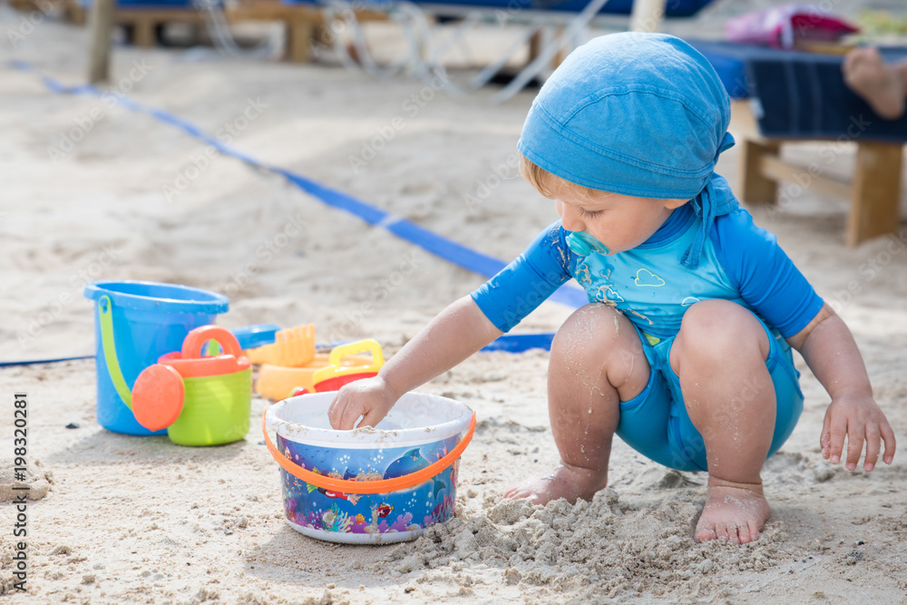 beautiful child plays at the sandy beach during the day beautiful child plays at the sandy beach during the day