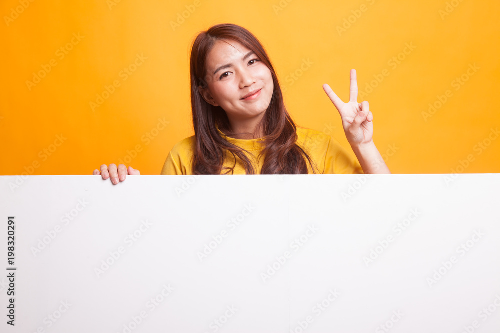 Young Asian woman show victory sign with blank sign in yellow dress Young Asian woman show victory sign with blank sign in yellow dress