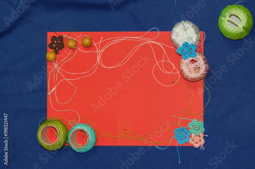 Red frame with tangles of knitting threads on blue background