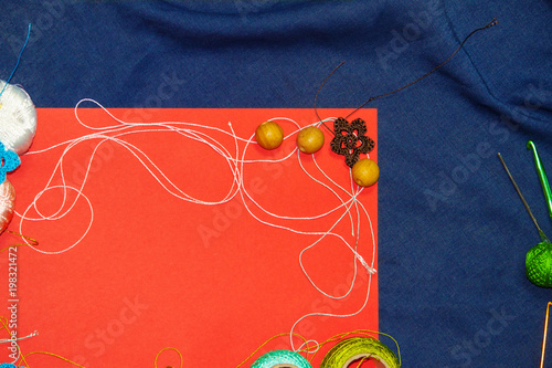 Red frame with tangles of knitting threads on blue background