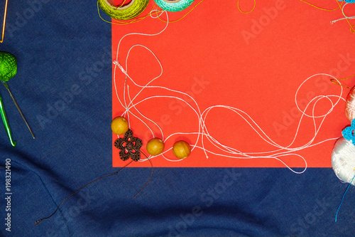 Red frame with tangles of knitting threads on blue background