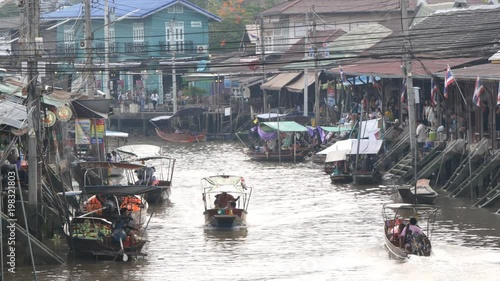 Samut Songkhram, Thailand - March 23, 2018: Amphawa floating market in Samut Songkhram, Thailand. Tourists shopping and boat ride around in Amphawa floating market.