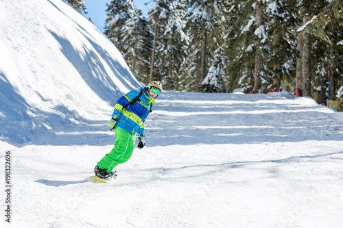 Image of man riding snowboard from snowy hill
