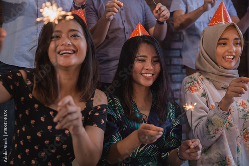  friends lighting sparklers together. celebrating