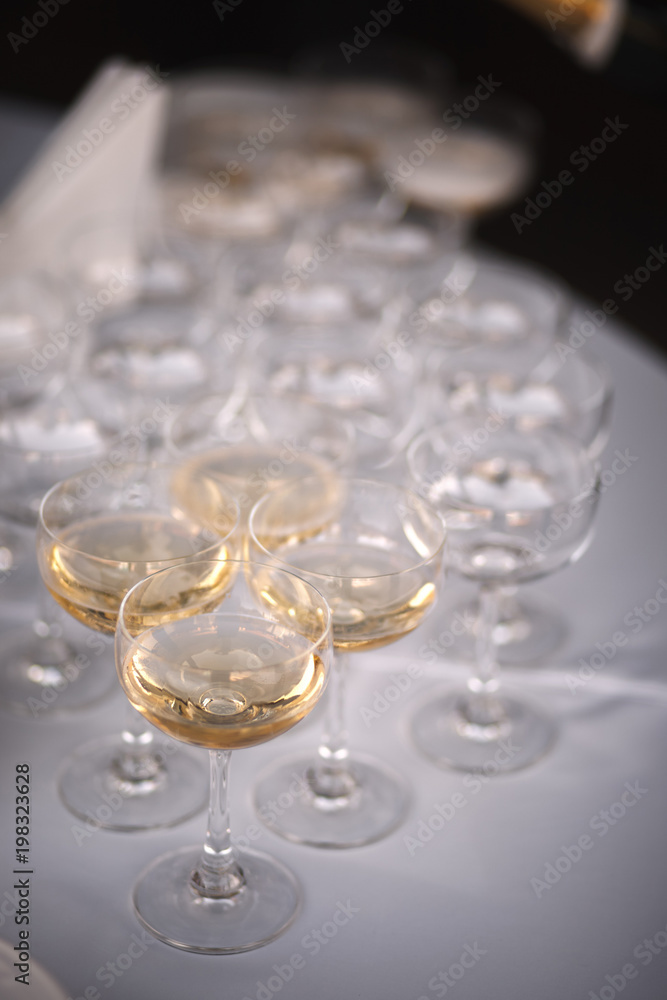 Row of champagne glasses on a white tablecloth Row of champagne glasses on a white tablecloth