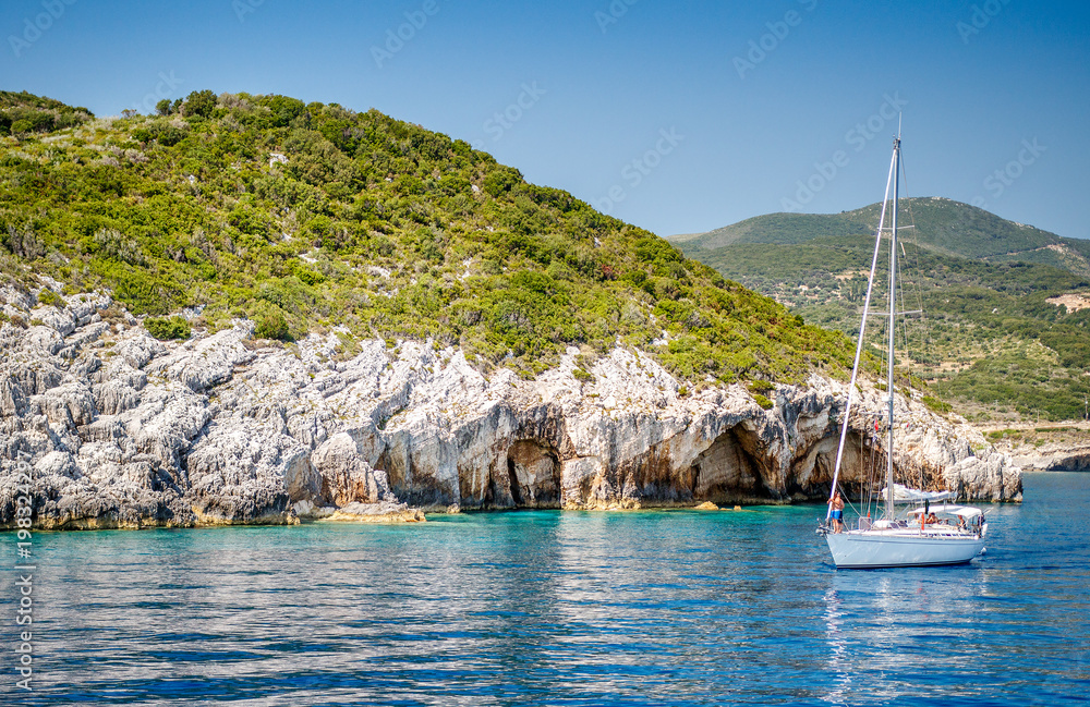 Blue caves at the cliff of Zakynthos island with white yacht, Greece