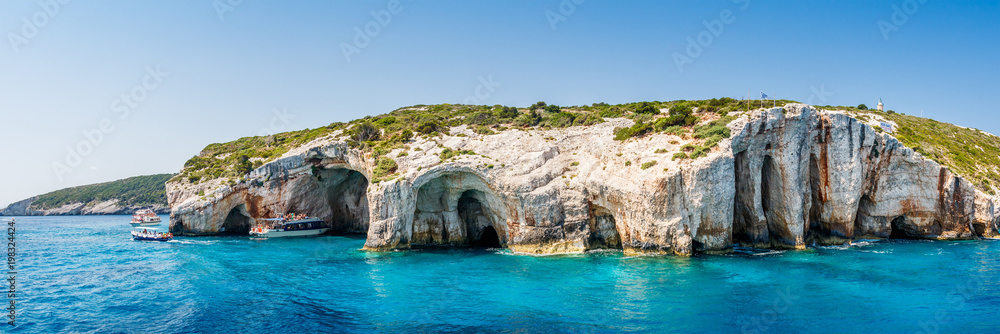 Tourist boats close to Blue caves at the cliff of Zakynthos island with, Greece, Panorama view