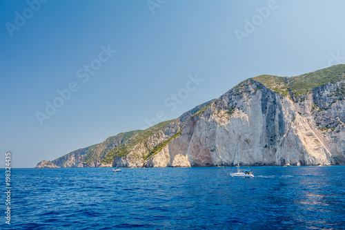 Yacht driving across ionian sea close to beautiful sunny Hill of Zakynthos island, Greece