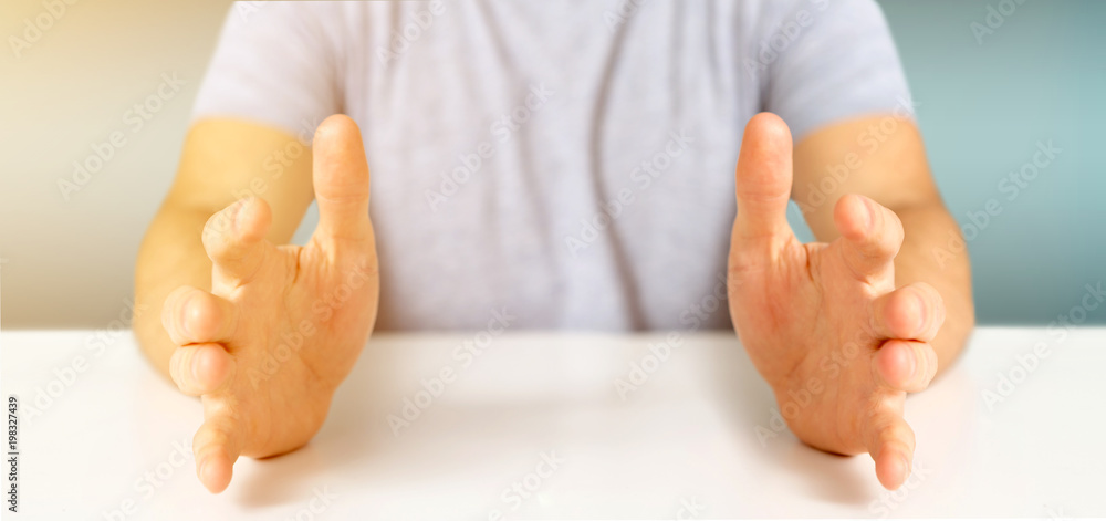 Empty holding hands of a young relaxed man over a desk Empty holding hands of a young relaxed man over a desk