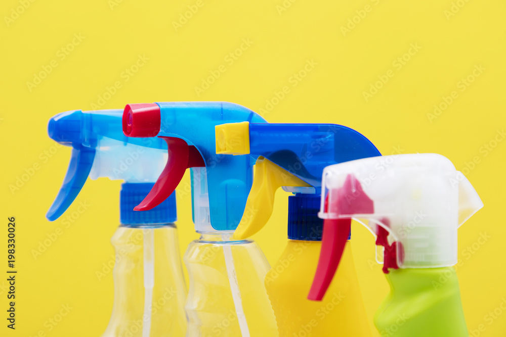 Spring cleaning spray bottle products on a bright yellow background