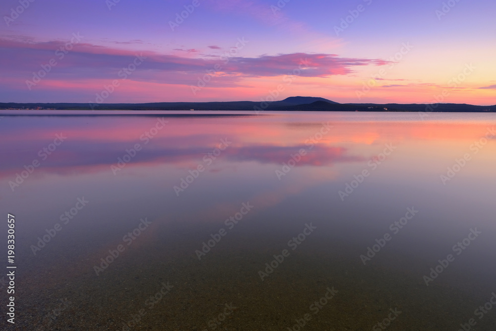 Beautiful pink sunset on the mountain lake