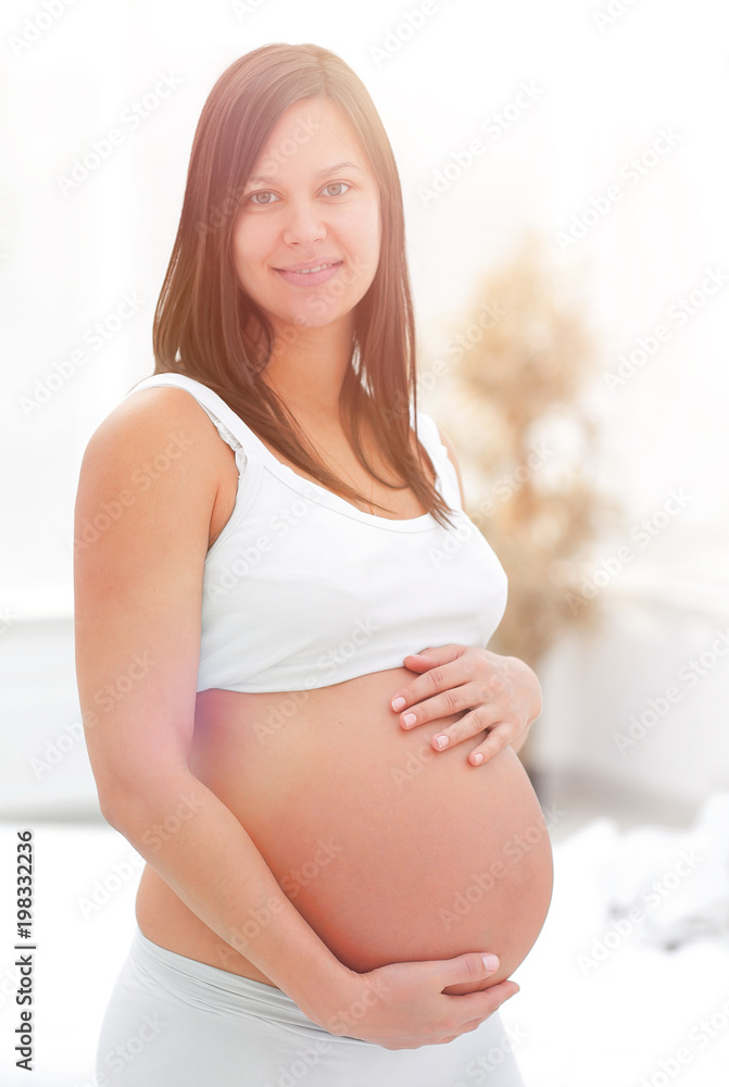 portrait of young pregnant woman on a light background. portrait of young pregnant woman on a light background.