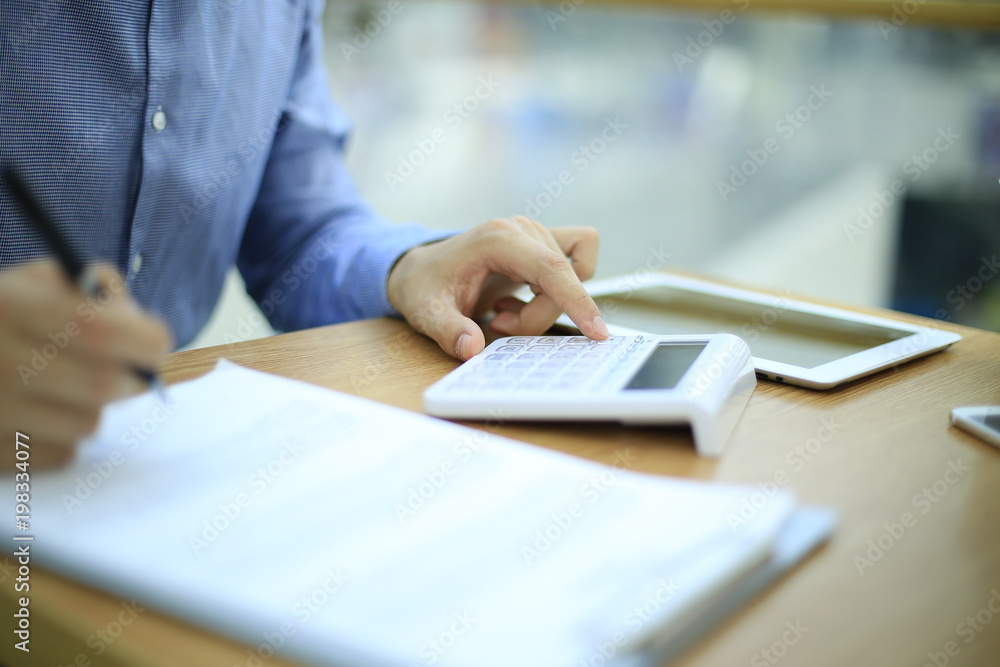 Man using calculator to count income and outcome. Man using calculator to count income and outcome.
