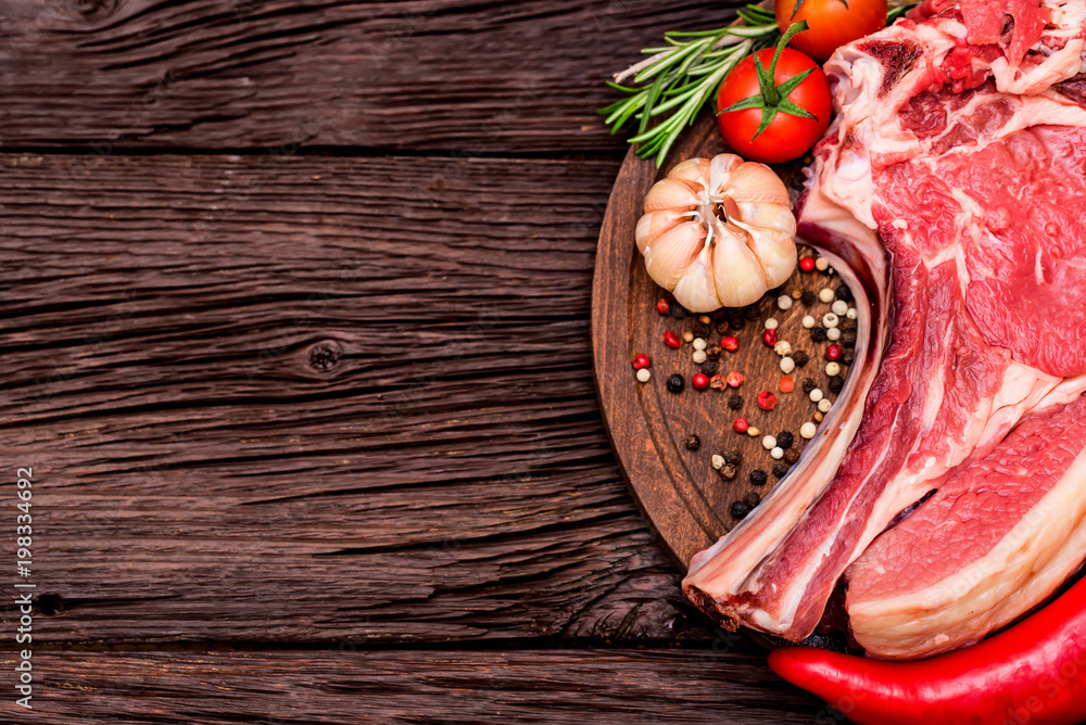 Raw beef steak with pepper, herbs and tomatoes Raw beef steak with pepper, herbs and tomatoes