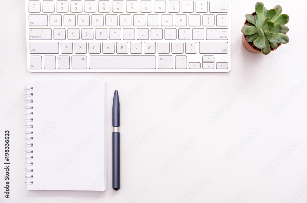 A fragment of the workplace with a keyboard and an opened notebook A fragment of the workplace with a keyboard and an opened notebook