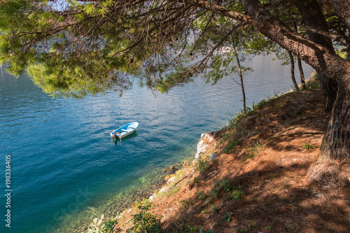 Small boat on a sea water under pine tree in Perast, Montenegro © Volodymyr Herasymov