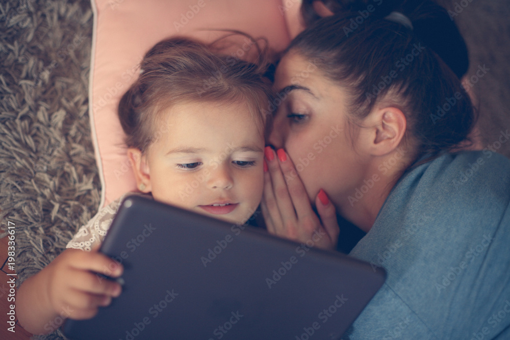 Mother whispered to her daughter on ear and using iPod. Mother whispered to her daughter on ear and using iPod.