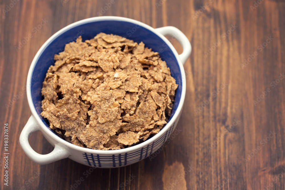 cereals in white blue bowl on brown background cereals in white blue bowl on brown background