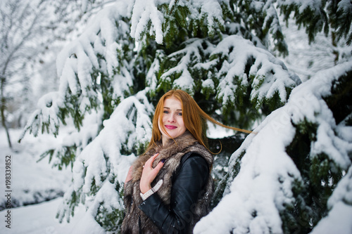 Red haired girl in fur coat walking at winter snowy park. © AS Photo Family