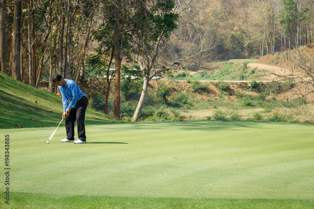 Man playing golf on a golf course. Man playing golf on a golf course.