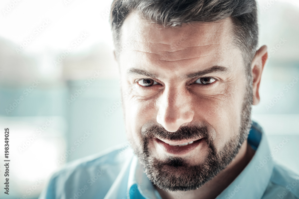 Obraz premium Positive thoughts. Attractive man feeling happiness while looking at you, having pause at work