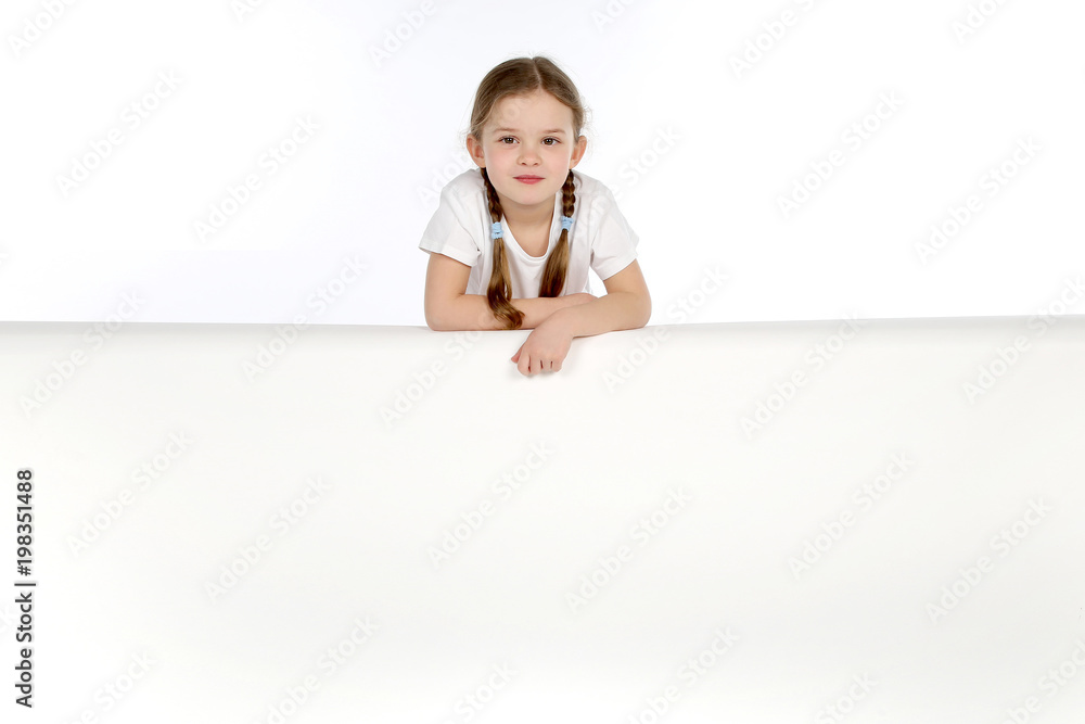 Hübsches kleines Mädchen mit Zöpfen lehnt auf einer weissen Wand Hübsches kleines Mädchen mit Zöpfen lehnt auf einer weissen Wand