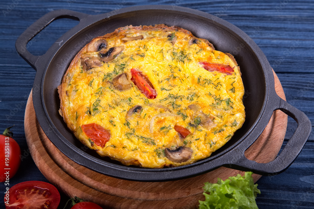 Omelette on an iron frying pan. Dish for the restaurant Omelette on an iron frying pan. Dish for the restaurant