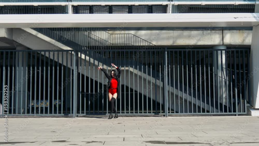Sexy female dancer in Vogue and Waacking dance style dancing in the city with urban background. Sexy female dancer in Vogue and Waacking dance style dancing in the city with urban background.