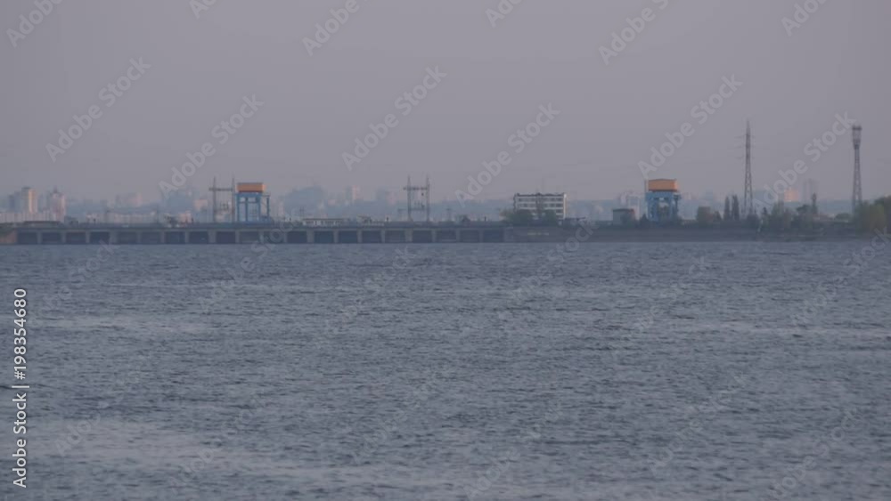 Kyiv hydroelectric power station on background of Kiev city, capital of Ukraine, with a bird flying in foreground Kyiv hydroelectric power station on background of Kiev city, capital of Ukraine, with a bird flying in foreground