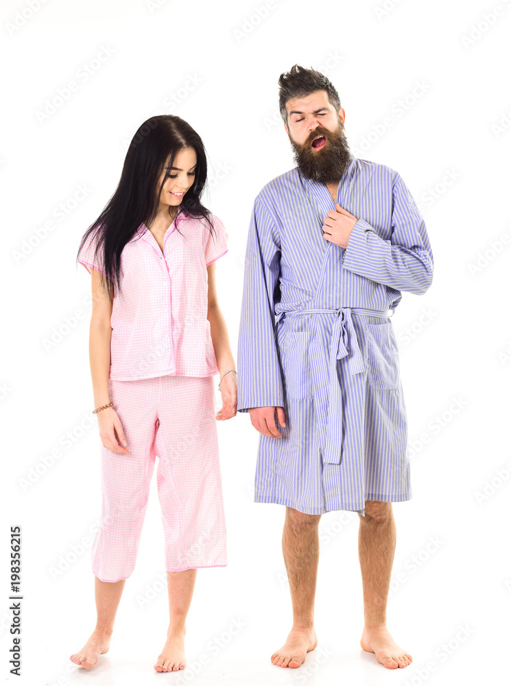 Couple in love in pajama, bathrobe. Couple hold hands together, isolated on white background. Couple, family on smiling faces in clothes for sleep looks sleepy in morning. Wake up and morning concept. Couple in love in pajama, bathrobe. Couple hold hands together, isolated on white background. Couple, family on smiling faces in clothes for sleep looks sleepy in morning. Wake up and morning concept.