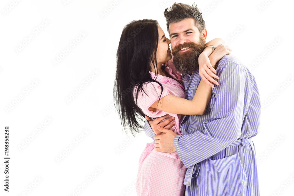 Relations goals concept. Couple in love hugging in pajama, bathrobe. Couple cuddling, girl kissing macho, isolated on white background. Couple, family on smiling faces happy in morning, copy space. Relations goals concept. Couple in love hugging in pajama, bathrobe. Couple cuddling, girl kissing macho, isolated on white background. Couple, family on smiling faces happy in morning, copy space.
