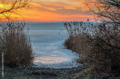 Beautiful winter sunrise. A frosty morning by the lake.