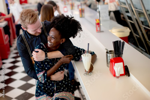 Couple hugging by the bar i...