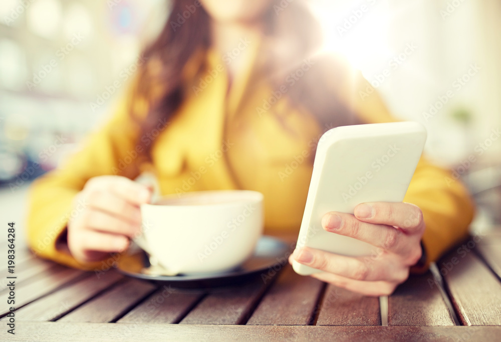 communication, technology, leisure and people concept - close up of young woman or teenage girl texting on smartphone and drinking cocoa at city street cafe terrace communication, technology, leisure and people concept - close up of young woman or teenage girl texting on smartphone and drinking cocoa at city street cafe terrace