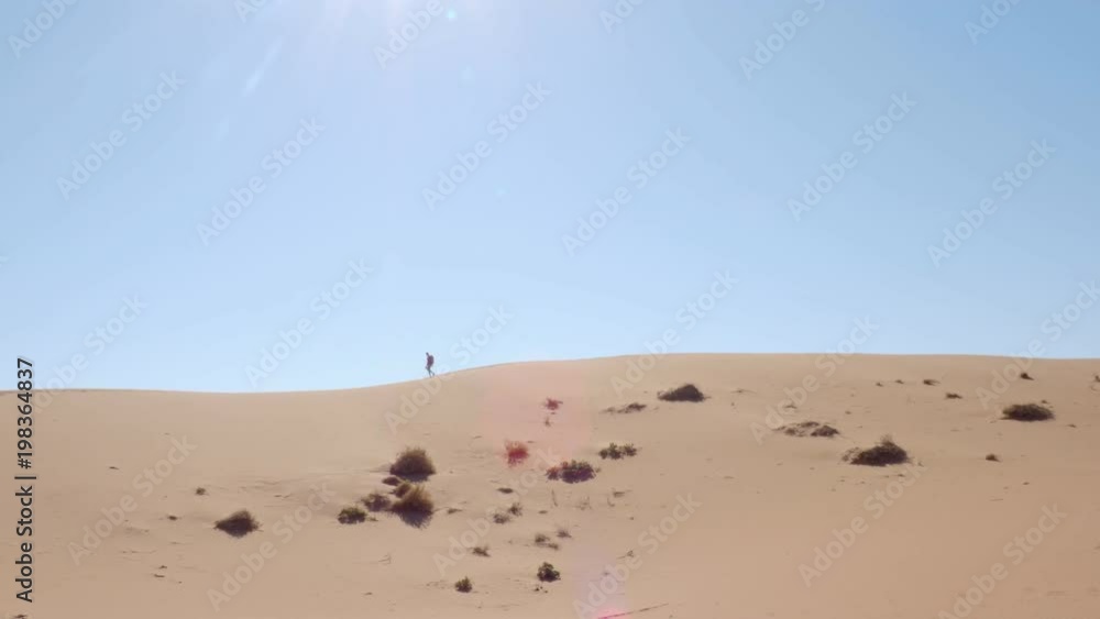 Man hiking in the desert sand exploring adventure in Namibia Africa Man hiking in the desert sand exploring adventure in Namibia Africa