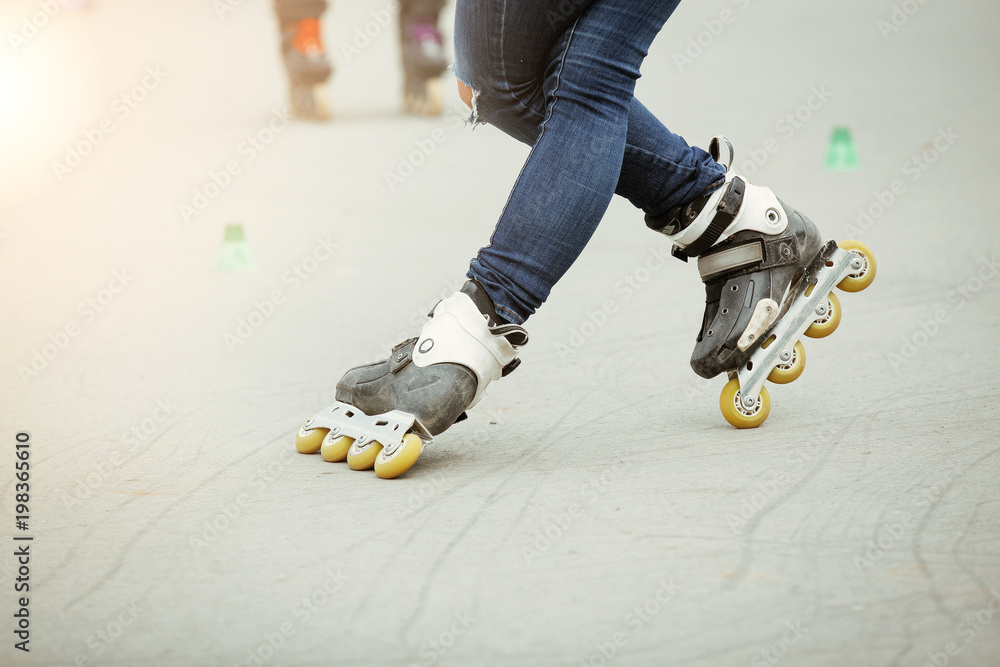 Rollerblading in the park. Feet on roller skates. Stock Photo Adobe Stock